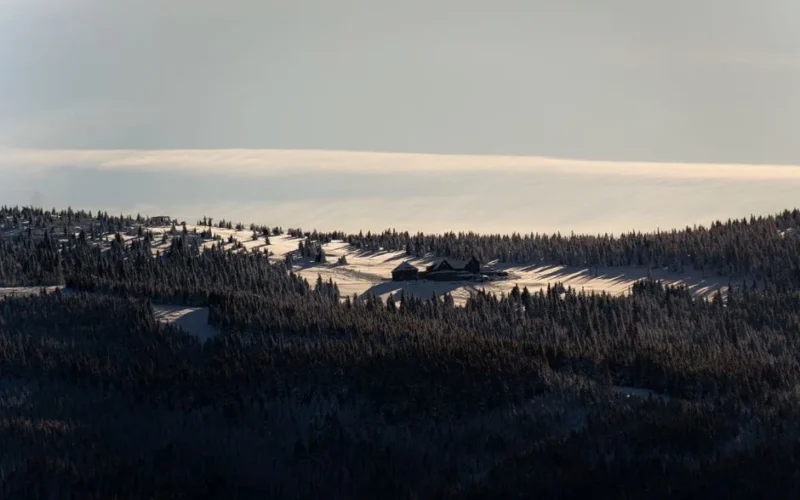 Stunning view of Karkonosze Mountains in winter, beautifully lit at sunrise with snow-covered peaks.