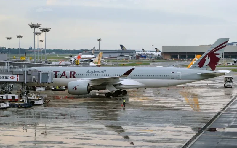 Qatar Airways airplane parked at international airport terminal during daytime.