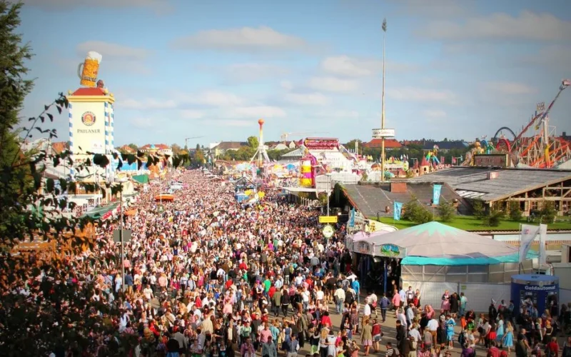 A lively scene at Oktoberfest in Munich with a massive crowd enjoying the festivities and attractions.