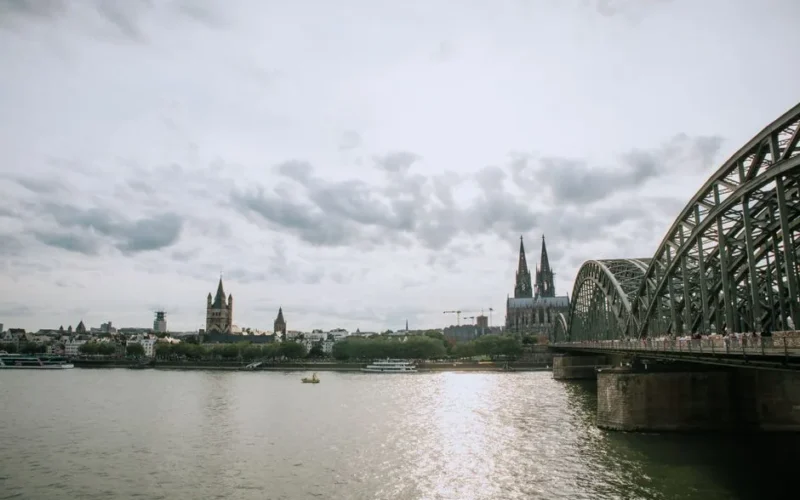 Captivating view of Cologne Cathedral with the Hohenzollern Bridge spanning over the Rhine River.