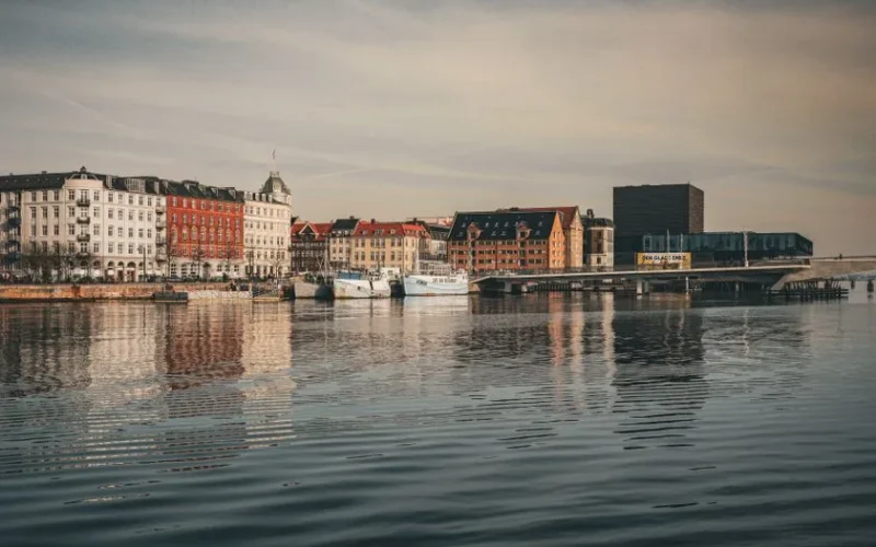 Charming cityscape of Copenhagen with colorful buildings reflecting in the calm water.