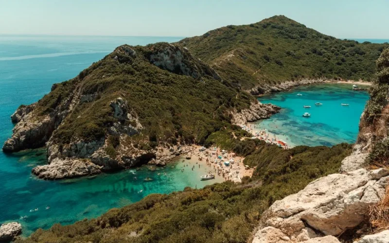 Breathtaking aerial shot of Porto Timoni Beach with turquoise waters and lush greenery in Corfu, Greece.
