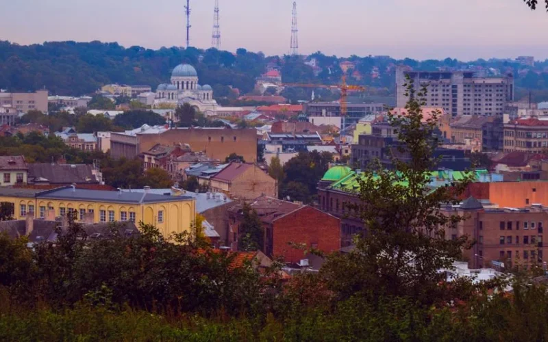 Aerial view of a historical European city with lush greenery and vibrant architecture.