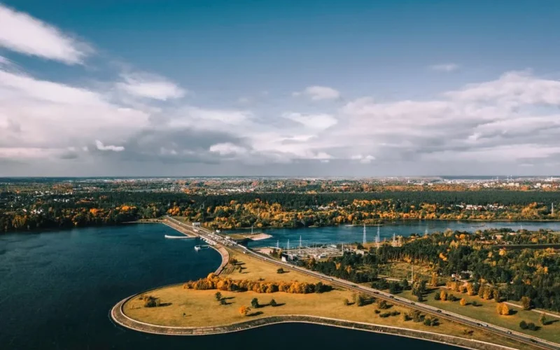 Stunning aerial view of Kaunas, Lithuania, showcasing autumn colors, rivers, and cityscape under a blue sky.