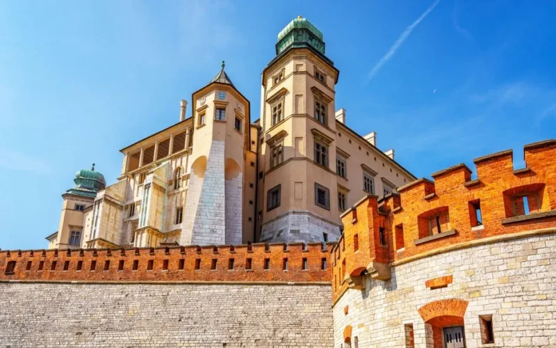 Historic Wawel Castle in Krakow, Poland, captured in vibrant sunlight against a clear blue sky.
