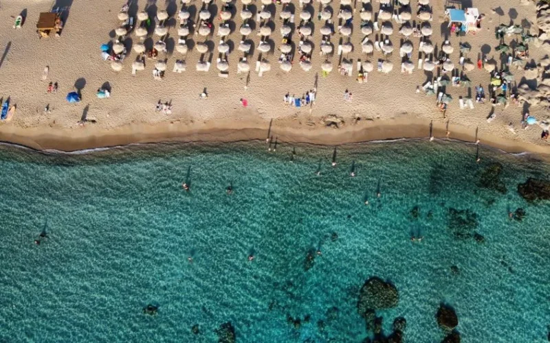 Aerial view of Chania beach, Greece with umbrellas and turquoise water.
