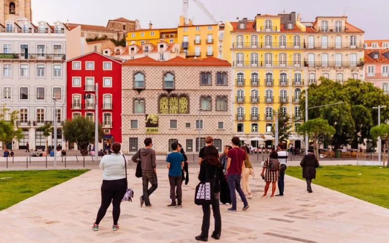 Vibrant Lisbon street scene featuring colorful buildings and a diverse group of tourists.