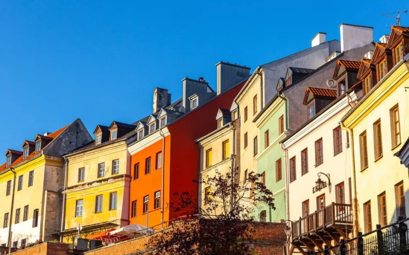 Vibrant townhouses in Old Town, Lublin, showcasing classic architecture against a clear blue sky.