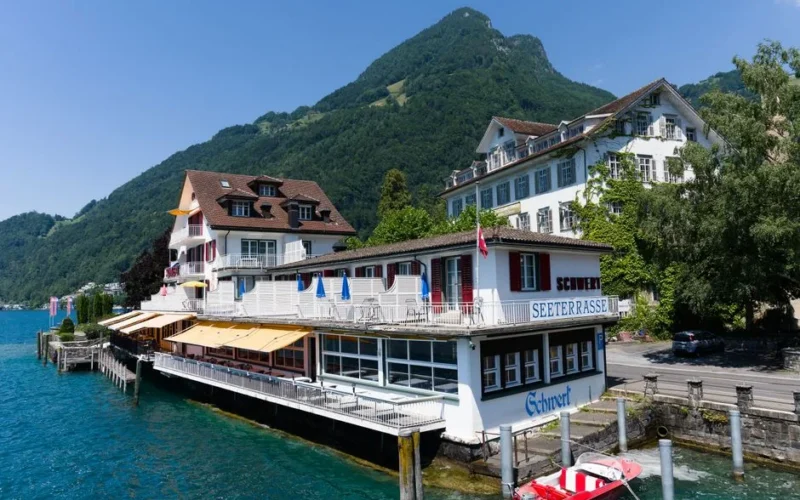 Lakeside restaurant in Brunnen, Switzerland by Lake Lucerne with mountain backdrop.