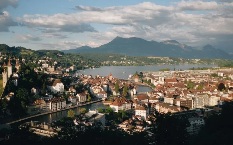 A picturesque aerial view of Lucerne, Switzerland featuring the cityscape, lake, and surrounding mountains.