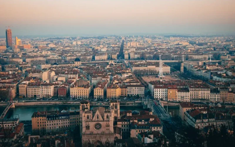Stunning aerial view of Lyon cityscape during sunset, showcasing historic architecture and vibrant city life.