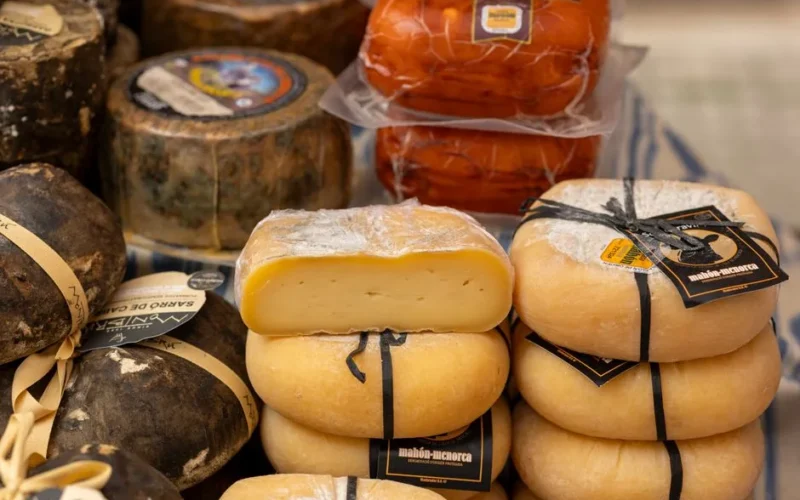 Assorted traditional Spanish cheeses displayed at a market stall in Palma, Spain.
