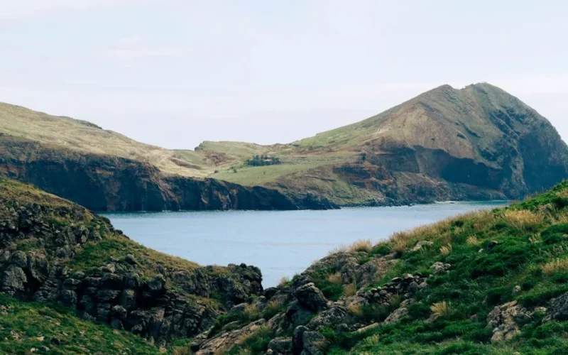 Explore the rugged coastal landscape of Madeira Island, Portugal, with lush green hills and rocky cliffs.