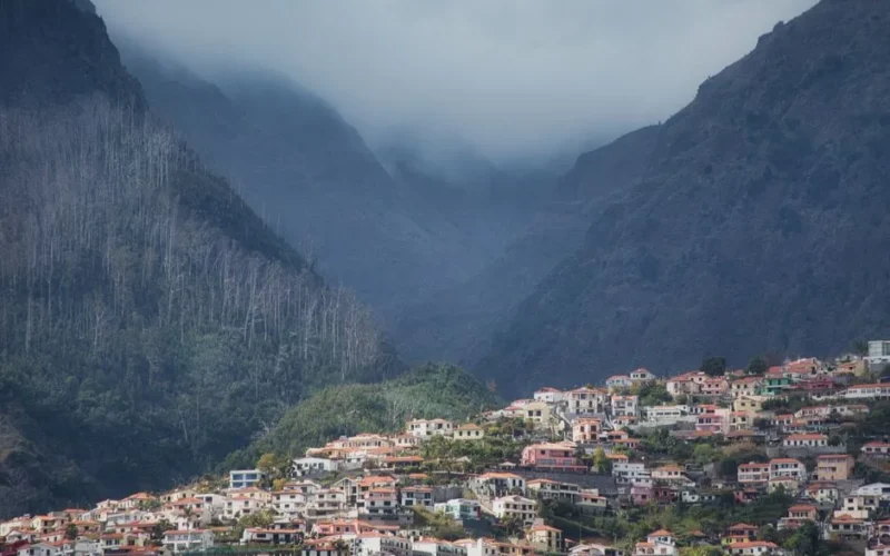Picturesque mountain village in Madeira, Portugal with lush green landscape and misty hills.