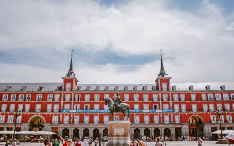 Vibrant view of Plaza Mayor in Madrid with historical architecture and bustling tourists.