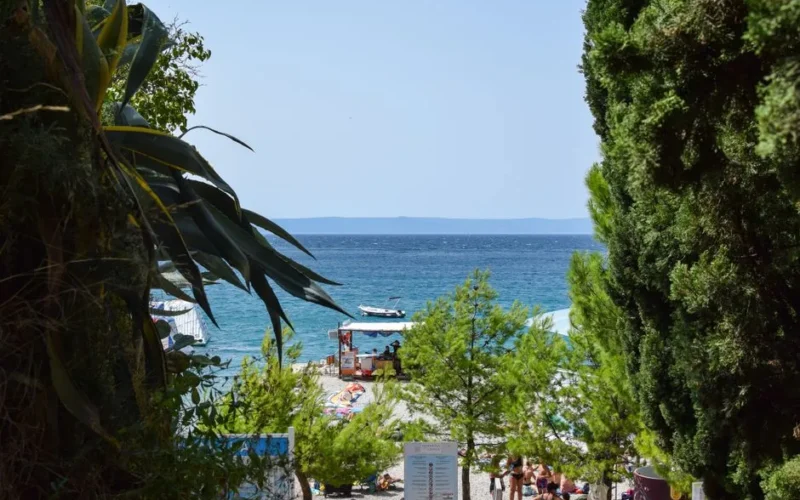 Explore the tranquil beauty of Makarska beach in Croatia, surrounded by lush greenery and clear blue waters.