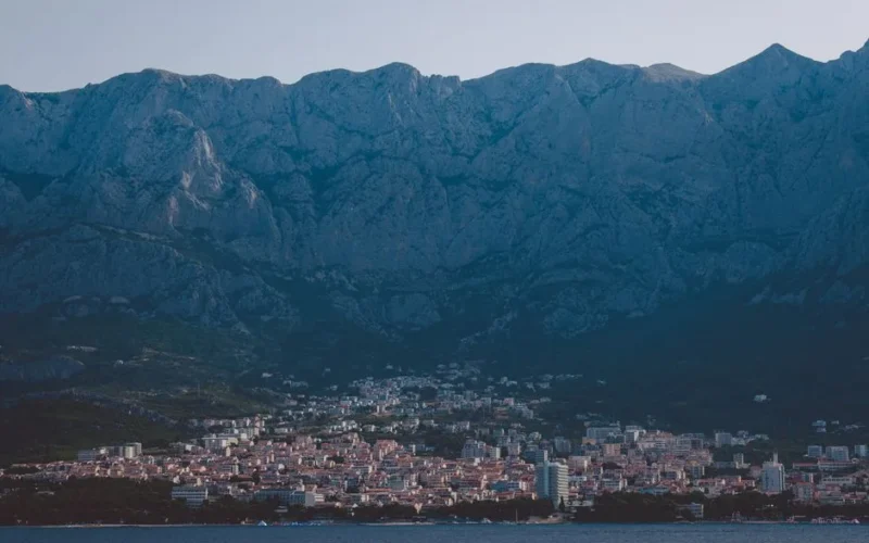 A breathtaking view of Makarska city nestled against a majestic mountain range by the sea.