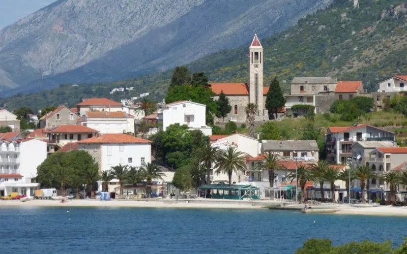 Picturesque landscape of Gradac, Croatia with coastal buildings and mountains in the background.