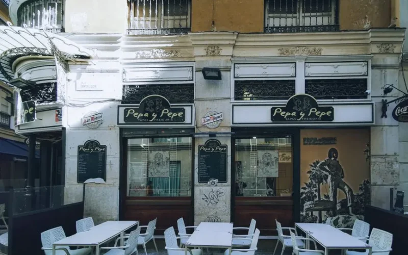 Quaint outdoor dining area at 'Pepa y Pepe' tapas bar in urban setting.
