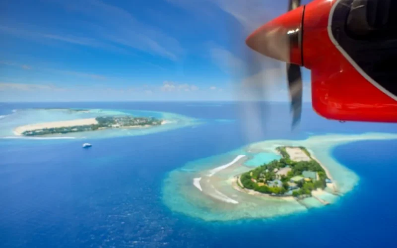 A stunning aerial shot of Maldivian islands captured from a seaplane, showcasing turquoise waters and lush landscapes.