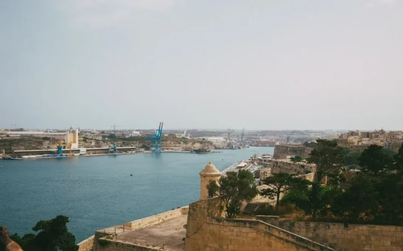 Beautiful view of Valletta harbor showcasing historic architecture and blue waters under an overcast sky.