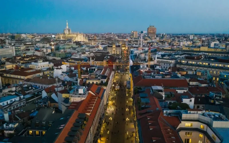 Stunning aerial view of Milan cityscape with illuminated streets and iconic cathedral.
