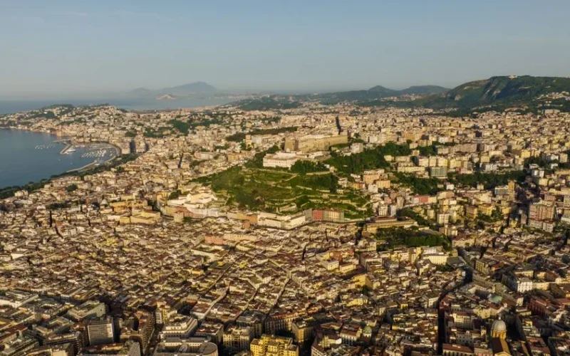 A stunning aerial cityscape of Naples with Mount Vesuvius in the background.