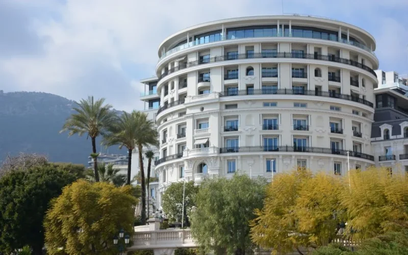Luxurious round hotel with palm trees, offering an elegant getaway.