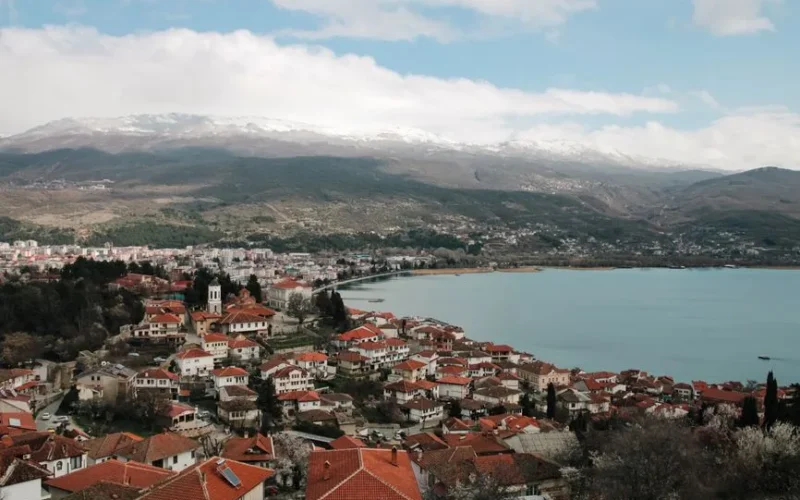 Aerial shot of Ohrid town overlooking Lake Ohrid with mountains in the background, timeless beauty.