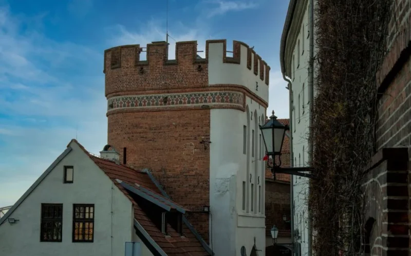 Capture of a medieval brick tower in the historic city of Toruń, showcasing Gothic architecture.