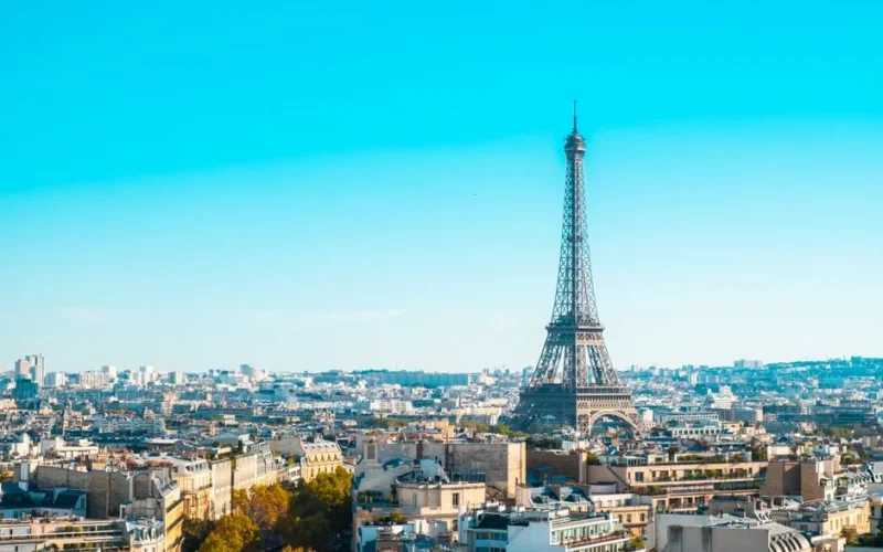 Eiffel Tower overlooking the cityscape of Paris under clear blue skies.