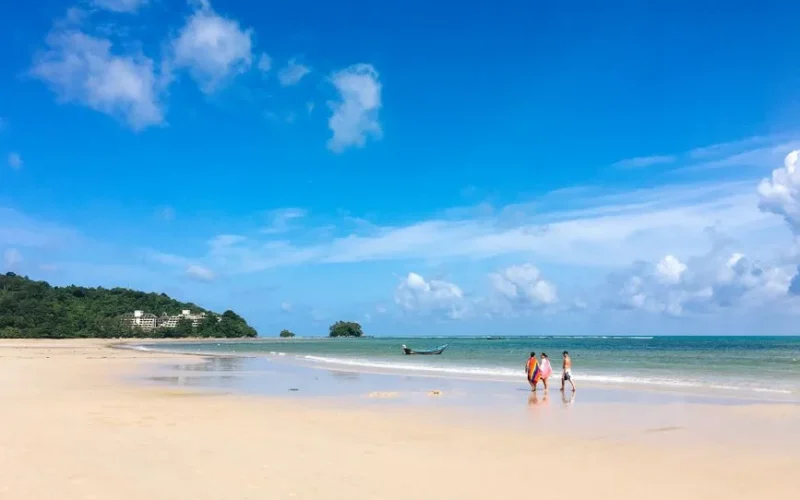 Beautiful tropical beach in Phuket, Thailand with blue skies, calm seas, and a serene atmosphere.