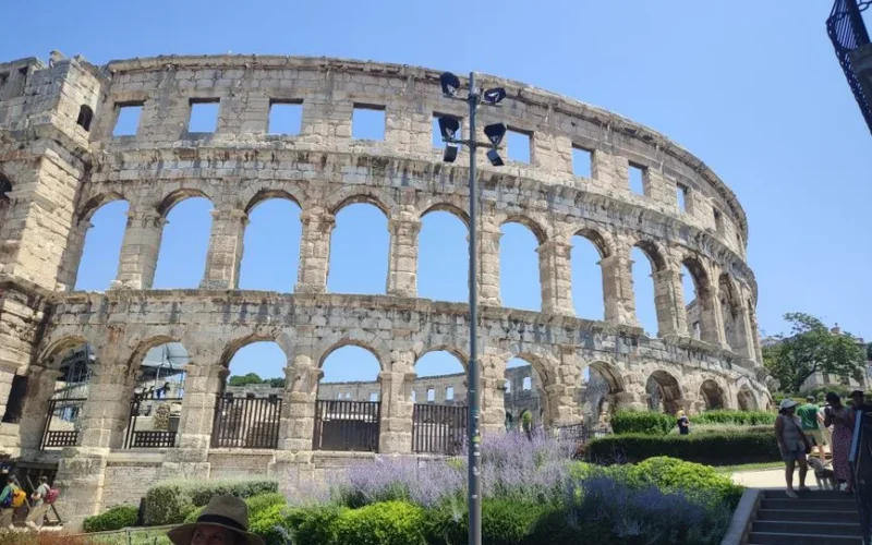 Explore the ancient Roman amphitheater in Pula, Croatia, under a clear summer sky.