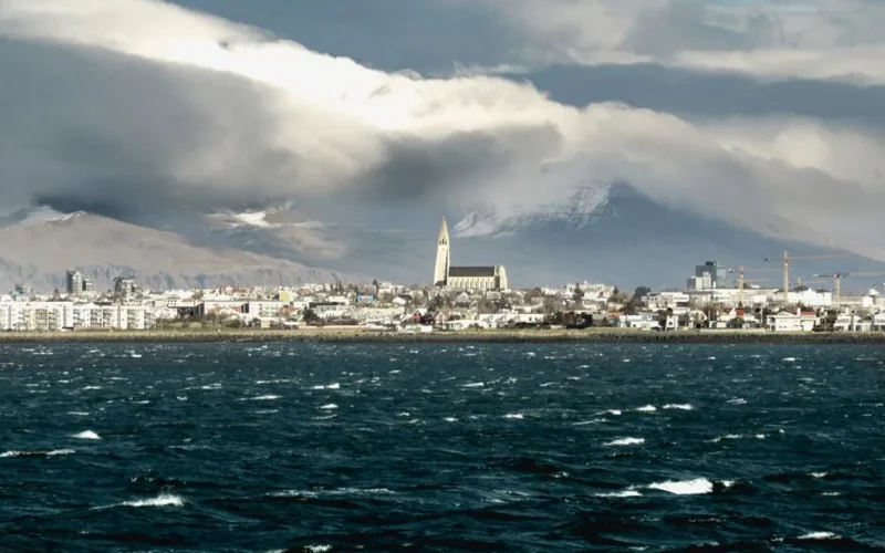 A stunning view of Reykjavík's skyline featuring the iconic Hallgrímskirkja church and ocean in Iceland.
