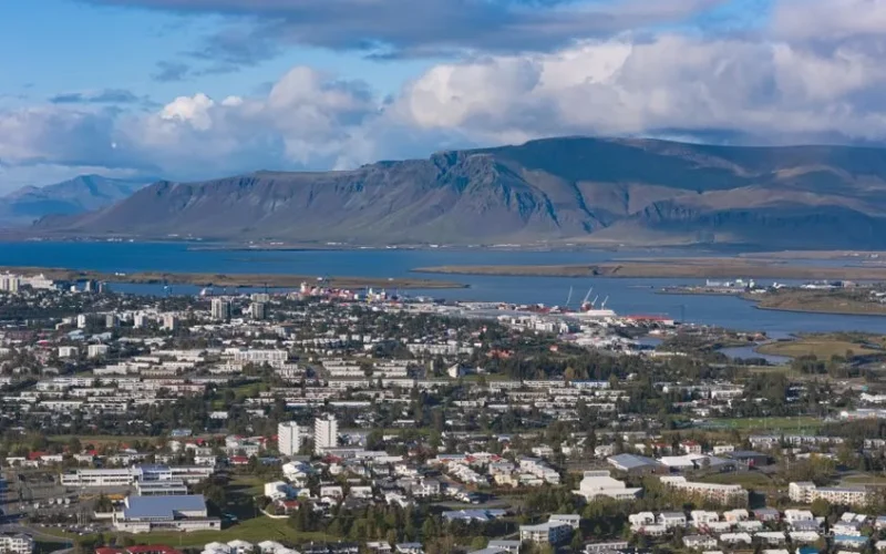 Stunning aerial view of Reykjavik with Esja Mountain in the backdrop during summer.