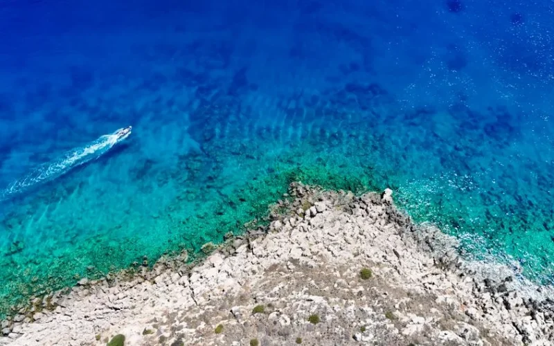 Experience the breathtaking contrast of turquoise waters and rocky shoreline in Rodos, Greece. Perfect for travel inspiration.