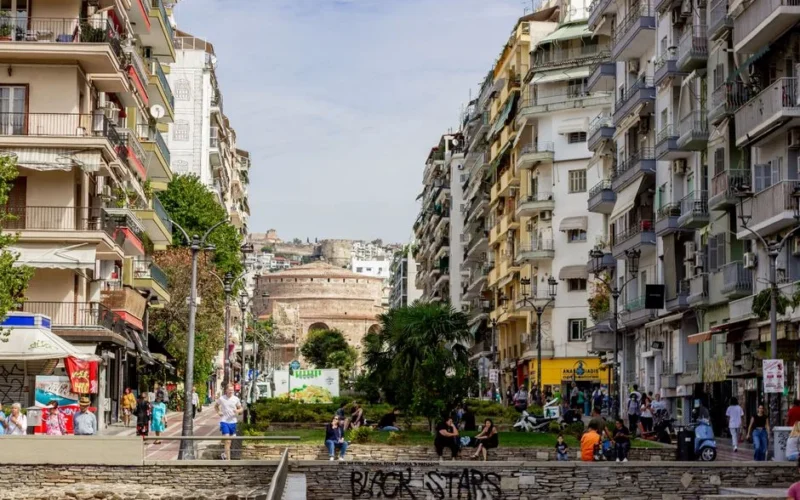 Bustling street scene in Thessaloniki, Greece with historic Rotunda in the background.