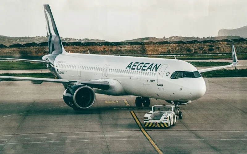 Aegean Airlines aircraft being towed at an airport, ready for takeoff.