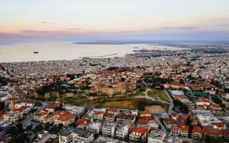 Aerial view of the historic city of Thessaloniki, Greece at sunset showing the cityscape and coast.