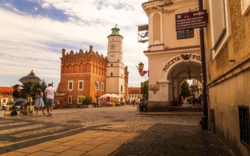 Explore the historic town square of Sandomierz featuring the picturesque town hall and surrounding architecture.