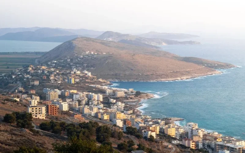 Explore the picturesque coastal view of Sarandë, featuring Lekursi Castle in the enchanting evening light.