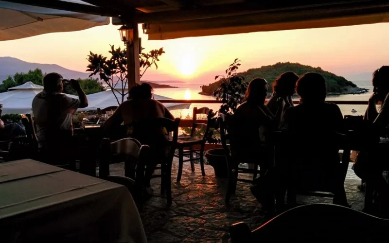 Elegant seaside dining in Ksamil, Albania during a vibrant sunset.