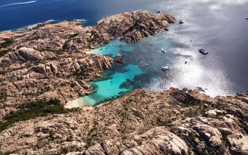 Stunning aerial view of turquoise waters and rugged coastline in La Maddalena Archipelago, Sardinia.