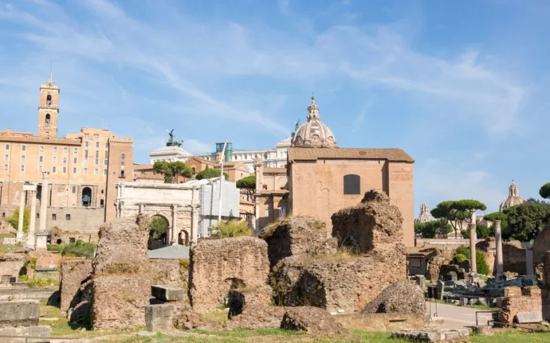 Explore the historic ruins of Rome under a clear blue sky.
