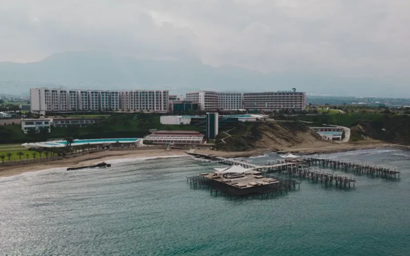 Aerial view of a luxurious beachfront resort with piers on a cloudy day.