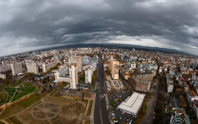 Dramatic aerial view of Sofia, Bulgaria showcasing urban architecture beneath cloudy skies.