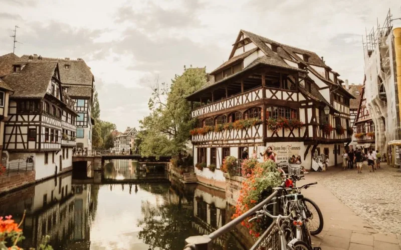 Picturesque view of Strasbourg's historic canal with charming half-timbered houses and cobblestone paths.