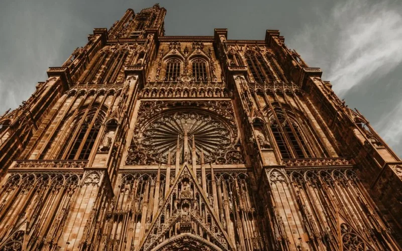 Striking low-angle view of Strasbourg Cathedral showcasing its Gothic architectural details and rose window.