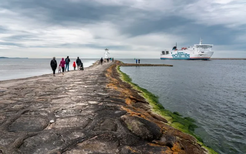 Tourists explore the iconic path leading to the Stawa Młyny lighthouse in Świnoujście, Poland.
