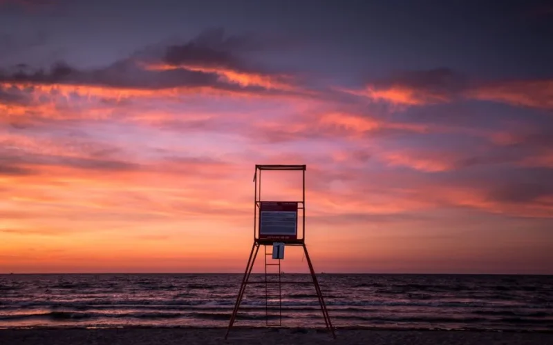 A serene sunset over the Baltic Sea with a lifeguard tower in Świnoujście, Poland.